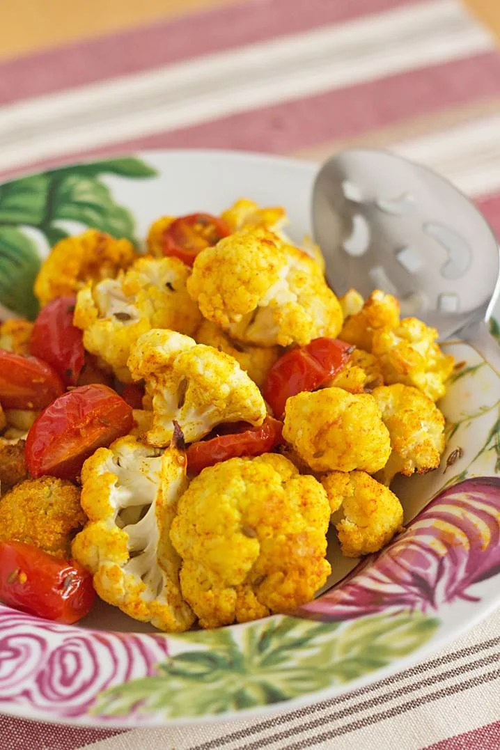 Indian Spiced Roasted Vegetables recipe - cauliflower, grape tomatoes and white cannellini beans are seasoned with tumeric, sweet paprika, and cumin. A great vegetarian dish for meatless Monday or as a side with chicken or lamb!